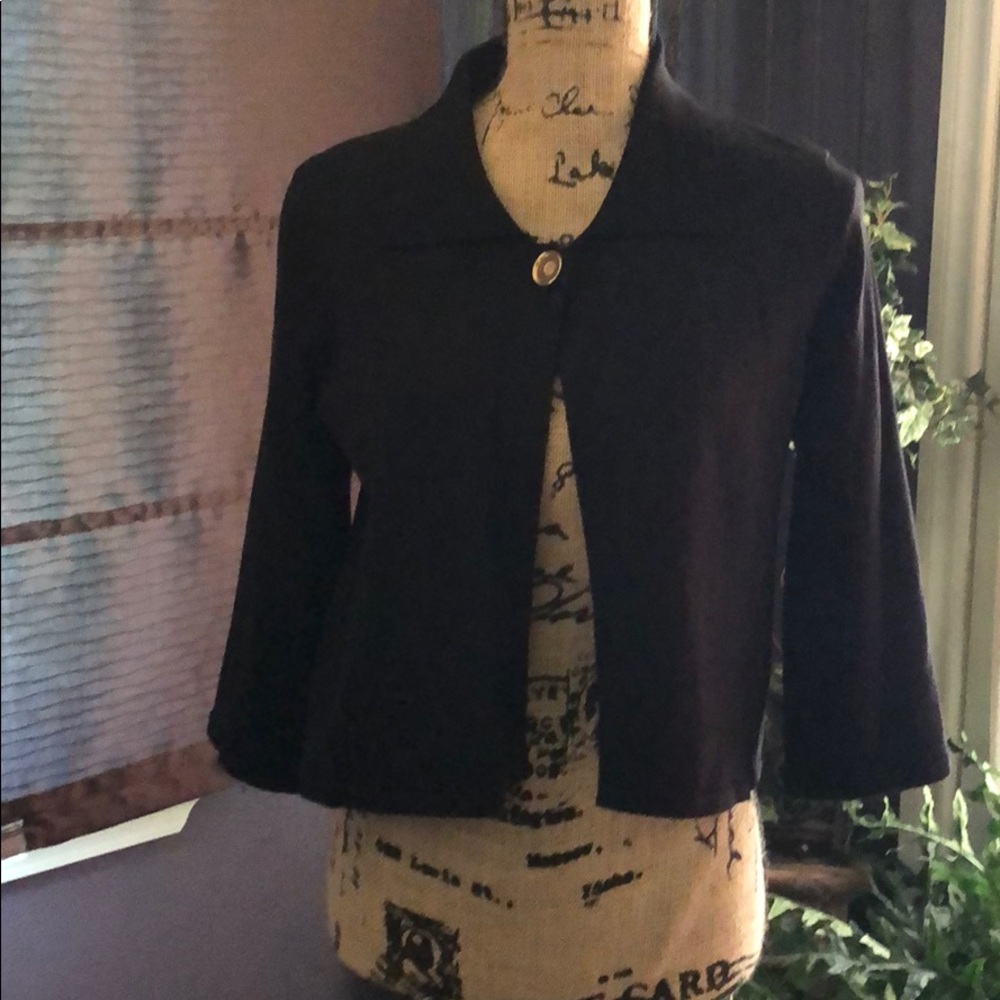 Black sweater cape with one gold button.